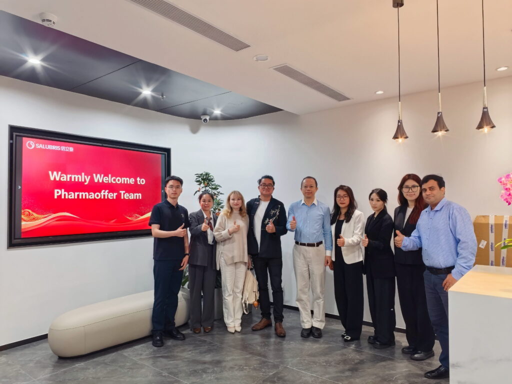 Julien Zhu from Pharmaoffer standing with the Shenzhen Salubris team in their corporate office.